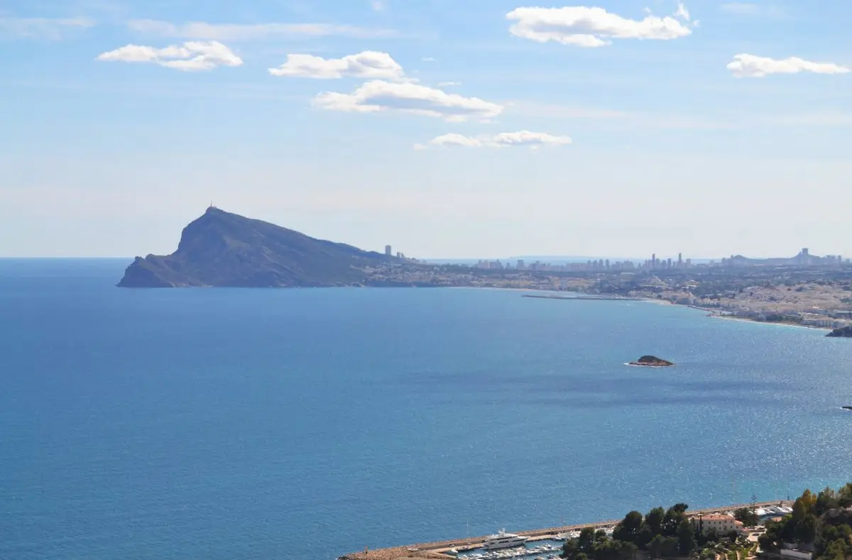 Vista desde el castellet del Mascarat sobre la bahía de Altea: el cabo de la Serra Gelada, detrás los rascacielos de Benidorm y, en el agua, la Illeta de l’Olla