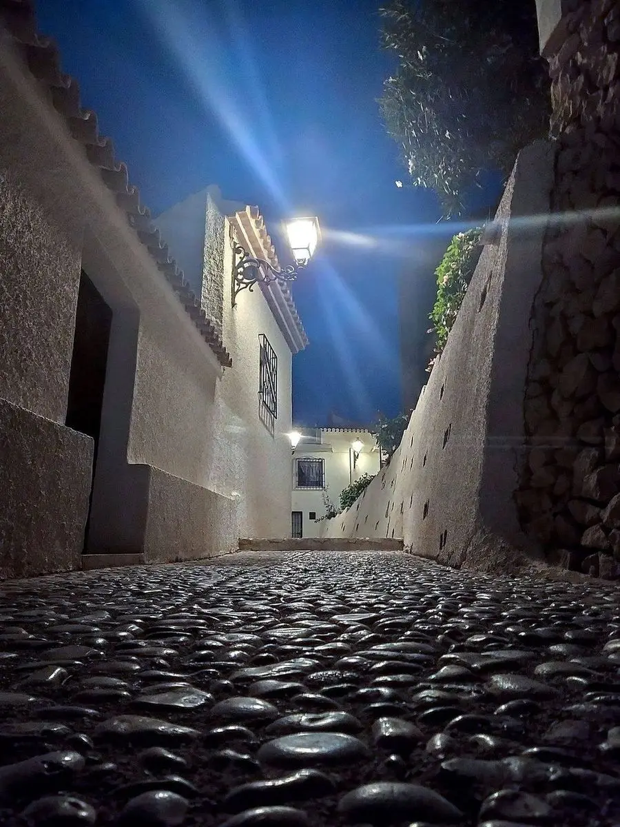 Una calle empedrada del casco antiguo de noche, tomada desde el suelo