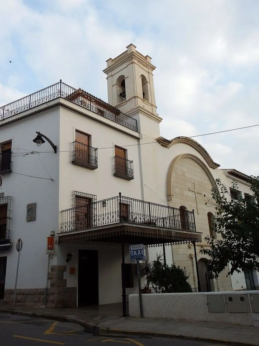 La iglesia franciscana desde la calle: el campanario de dos huecos sobre el edificio conventual contiguo, con balcones de forja